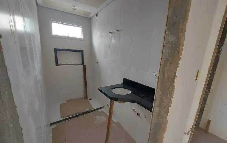 Banheiro em obra com paredes revestidas, nicho e bancada