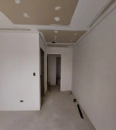 Circulação do apartamento em obra, com forro de gesso e paredes regularizadas