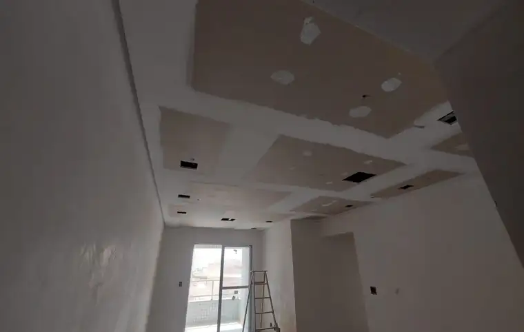 Sala em obra com forro de gesso recortado para iluminação