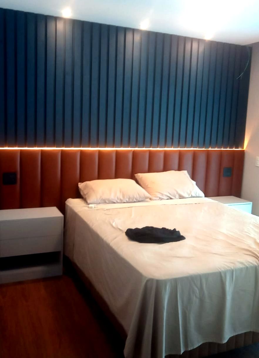 Quarto planejado com painel ripado e cabeceira estofada, projeto Alencar Interiores