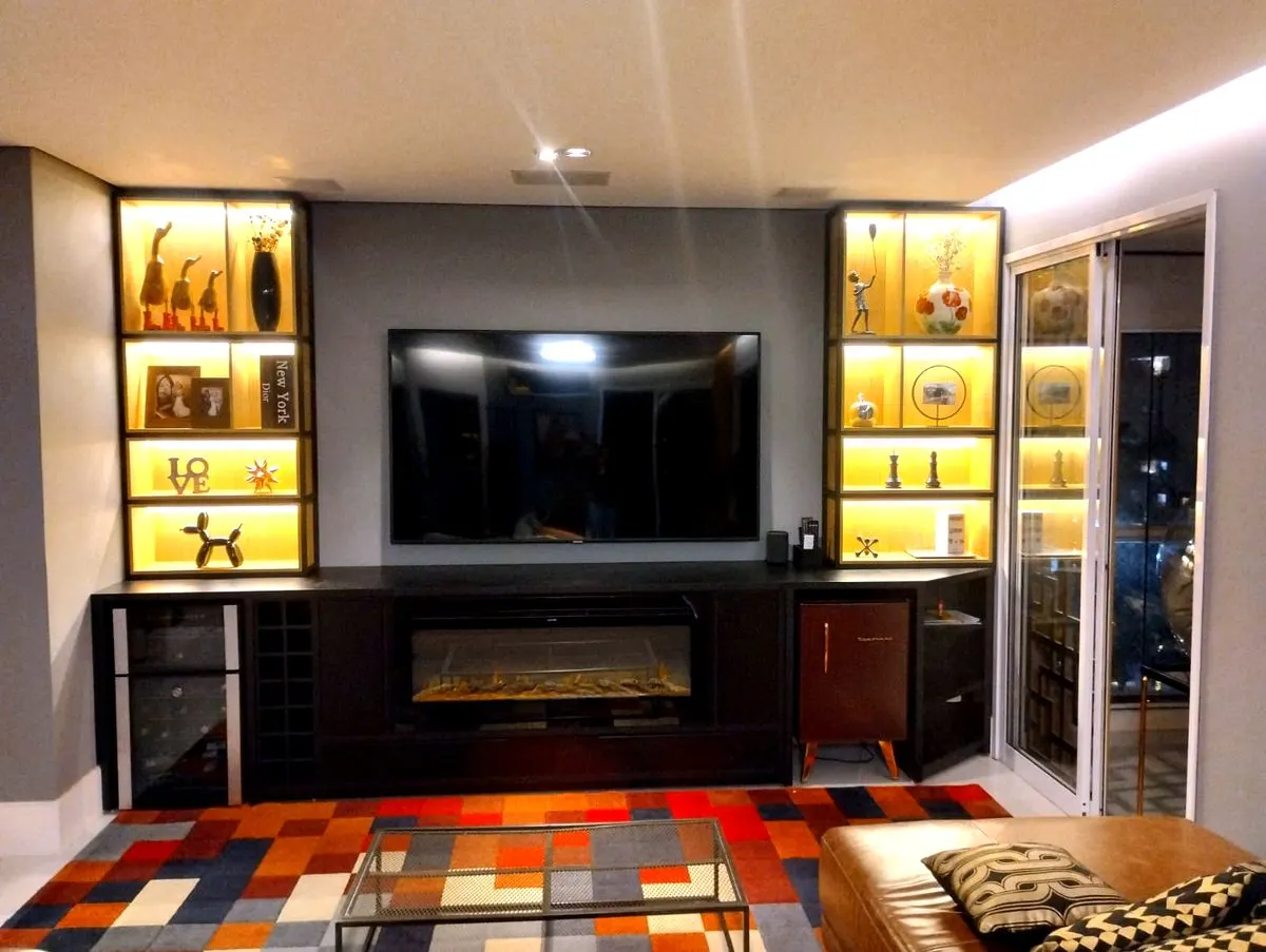 Estante planejada com painel de TV, nichos iluminados e lareira