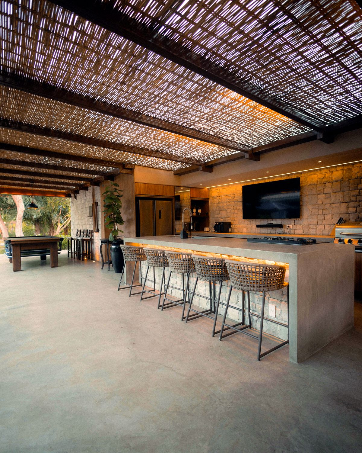 Área gourmet planejada com bancada e churrasqueira, projeto Alencar Interiores